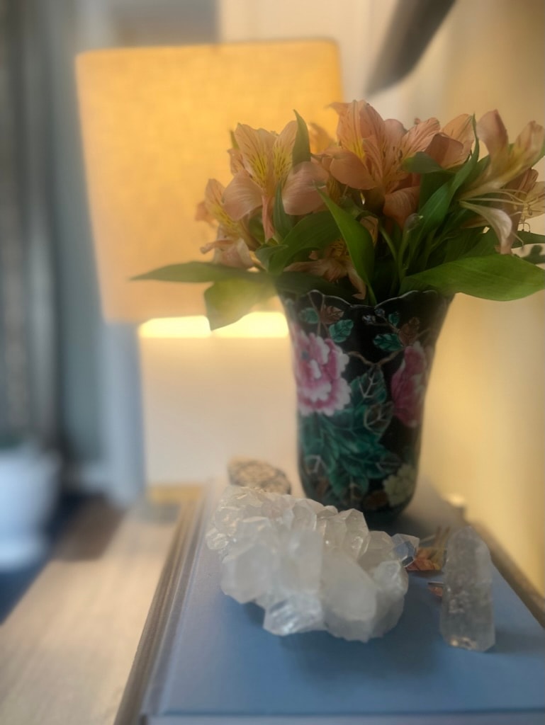 Flowers in decorative vase with crystals and warm lamp light